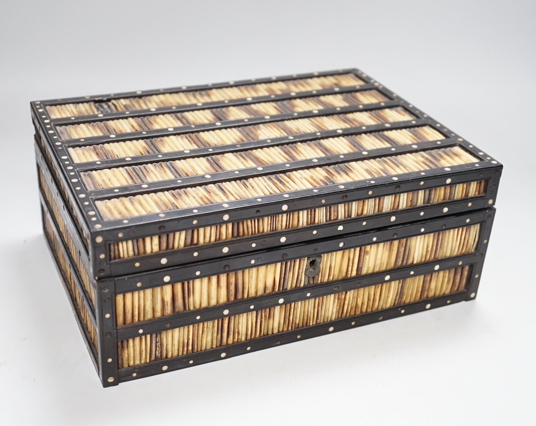 A 19th Century Ceylonese ebony, porcupine quill and bone inlaid sewing box with contents including cotton reels, 28cm wide